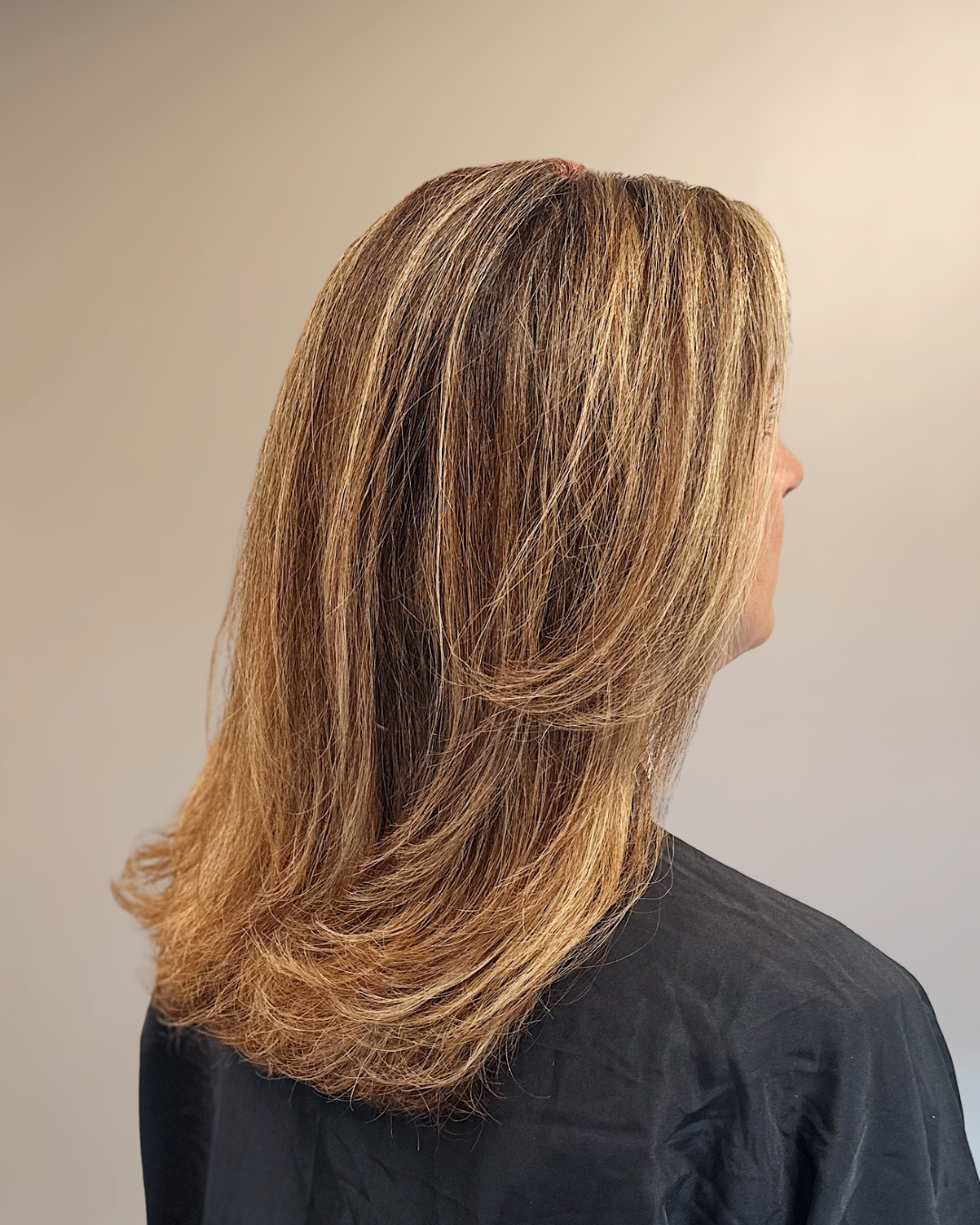 Layered honey blonde with face-framing highlights and shadow root
