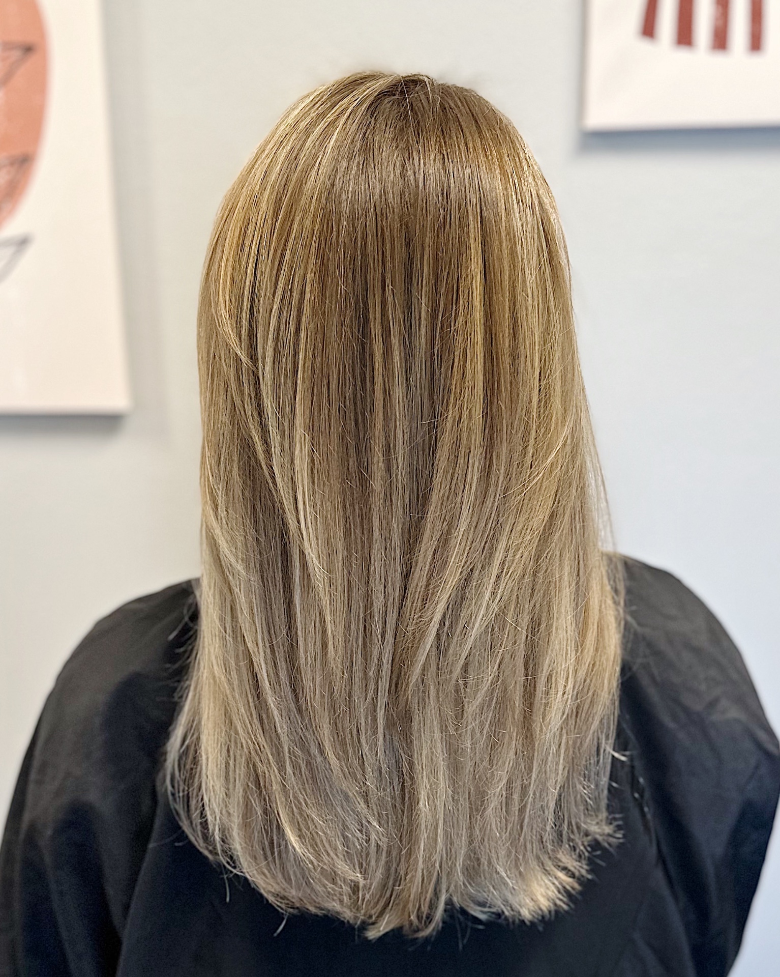 Back view of long blonde hair with natural dimensional highlights and seamless root melt styled straight by Jenna Schermerhorn in Glen Allen, VA